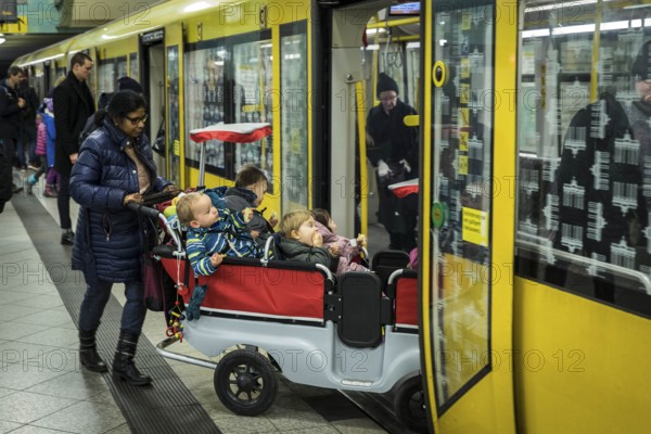 DEU Germany Germany Berlin Carer with pram for several kindergarten children in the underground