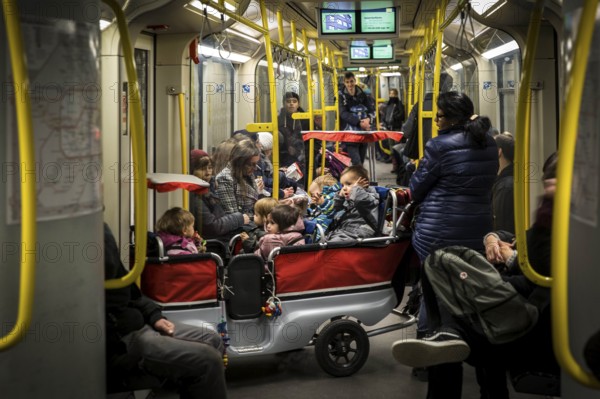 DEU Germany Germany Berlin Carer with pram for several kindergarten children in the underground