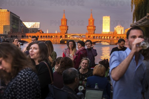 DEU Germany Germany Berlin Sunset on the terrace of the Fluxbau with the Oberbaum Bridge in the background