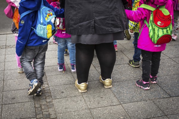 DEU Germany Germany Berlin A kindergarten teacher waits with children at a traffic light