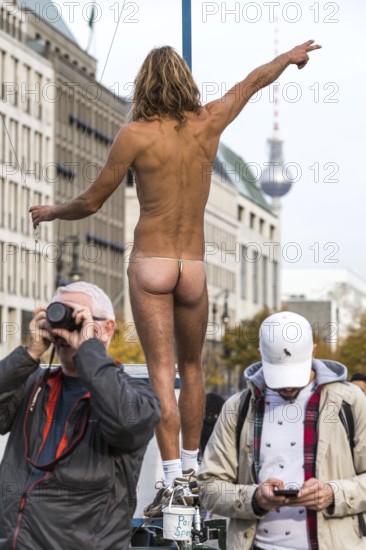 DEU Germany Germany Berlin A naked man demonstrates on a bicycle in front of the Brandenburg Tor