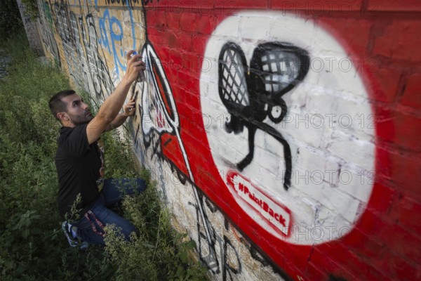 Germany Germany DEU Berlin Graffiti artist Ibo Omari in front of one of his works on a playground in Schöneberg