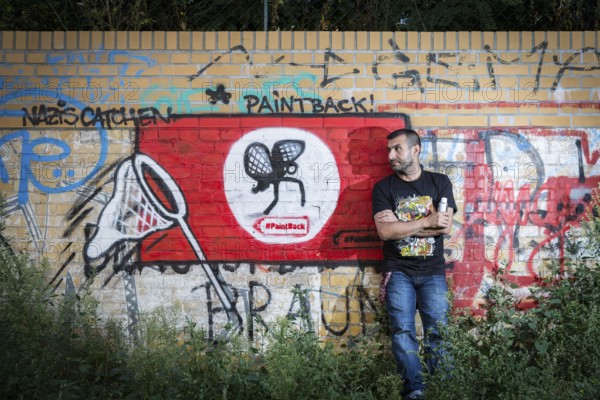 Germany Germany DEU Berlin Graffiti artist Ibo Omari in front of one of his works on a playground in Schöneberg