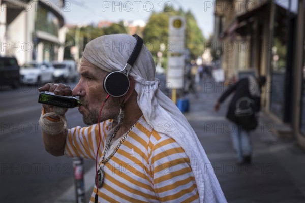 DEU Germany Germany Berlin A homeless man holds his mobile phone and a book in his hand