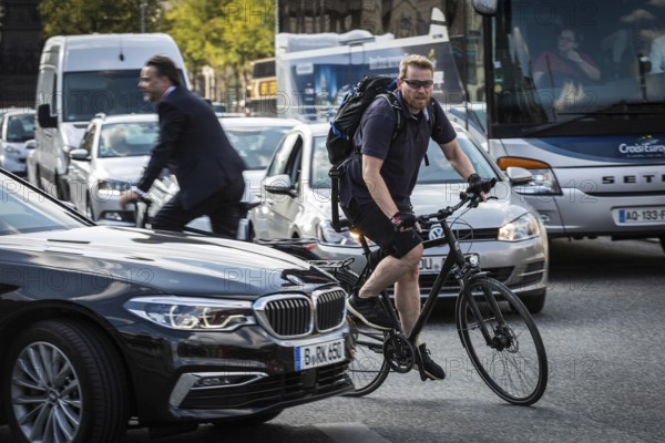 DEU Germany Germany Berlin Cyclist between cars in heavy traffic in the city centre