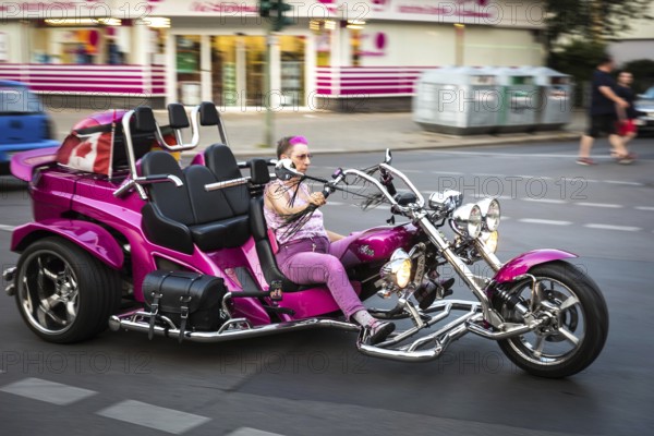 DEU Germany Germany Berlin A woman rides a fun bike through Uhlandstraße