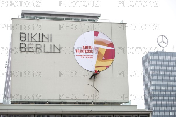 DEU Germany Germany Berlin A worker removes the outdoor advertising for a spring installation in the Bikini-Haus