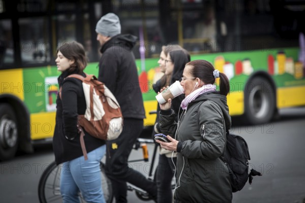 DEU Germany Germany Berlin A pedestrian crosses a pedestrian crossing near Bahnhof Zoo with a coffee cup