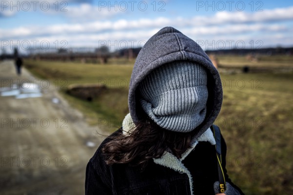 POL Poland Auschwitz Scenes at the Holocaust Memorial .A woman covers her faces dü to cold winds. Each year more than 2 million visitors are touring through the remains of the former German Nazi concentration and extermination camp Auschwitz-Birkenau. More than 1, 1 million people have been killed here between 1940 and 1945