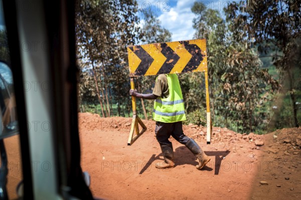 RWA RWANDA Rwanda Rusumo A worker carries a road sign across a construction site