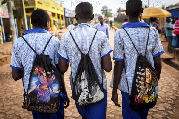 RWA RWANDA Rwanda Kayonza students in uniform carry backpacks with their idols Lionel Messi and Bob Marley
