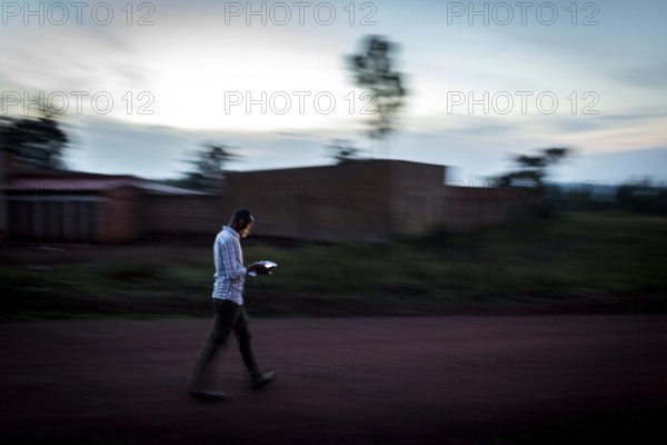 RWA RWANDA Rwanda Rukara A student looks at his smartphone while walking