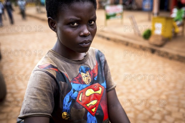 RWA RWANDA Rwanda Kayonza A young woman with a bicycle shows her Superman shirt