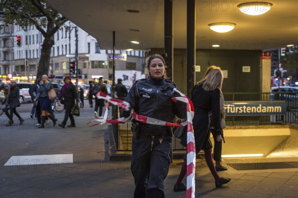 DEU Germany Germany Berlin Fire brigade operation on Kurfürstendamm. Storm Xavier had caused trees to fall onto the street. Policewoman lifts the underground barrier