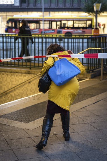 DEU Germany Germany Berlin Fire brigade operation on Kurfürstendamm. Storm Xavier had caused trees to fall onto the street. Woman crosses a barrier at an underground entrance