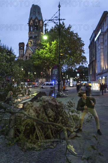 DEU Germany Germany Berlin Fire brigade operation on Kurfürstendamm. Storm Xavier had caused trees to fall onto the street. Passers-by pose for souvenir photos