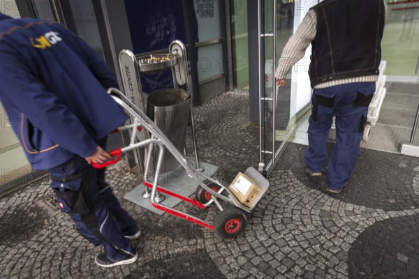 DEU Germany Germany Berlin A courier with grocery orders enters the Europe Centre while a parcel courier leaves