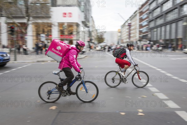 DEU Germany Germany Berlin A bicycle courier from Foodora starts off together with a cyclist at a traffic light on Tauenzien