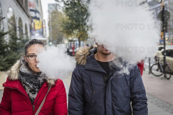 DEU Germany Germany Berlin A couple with an e-cigarette blowing out vapour