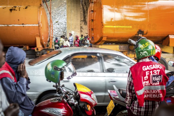 RWA RWANDA RUANDA Kigali Taxi drivers with motorbikes and bicycles wait under a bridge for the end of a rainstorm