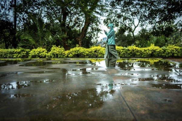 RWA RWANDA RUANDA Kigali A visitor plays in the puddles of water on a mass grave at the genocide memorial