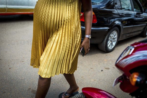 RWA RWANDA RUANDA Kigali A pregnant woman in a golden dress walks through the streets of Remera district