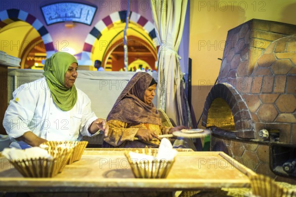 Egypt Hurghada Two elderly Egyptian women bake bread during an evening promotional event for Egyptian tourism