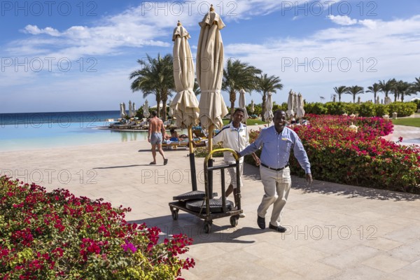 Egypt Hurghada Two hotel employees transport parasols