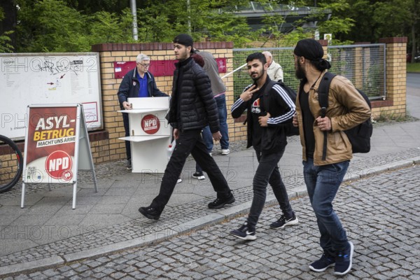 DEU Germany Germany Berlin Open day for the presentation of a new anchor centre on the grounds of the Karl Bonhoeffer mental hospital in Reinickendorf Migrants pass an NPD stand