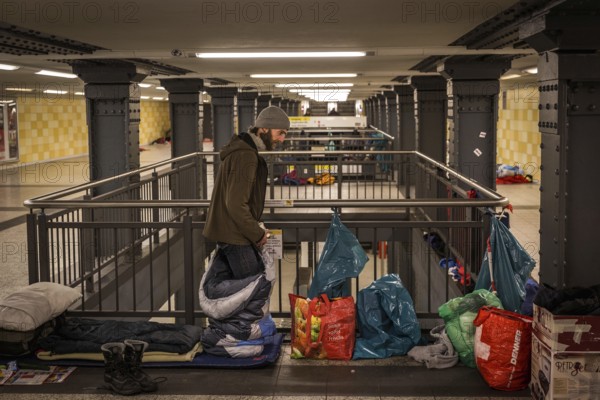 DEU Germany Germany Berlin Homeless people spend the night in a passageway at Lichtenberg underground station. Like Moritzplatz, the station has been made available by the BVG for overnight stays during the winter months.homeless man gets into his sleeping bag