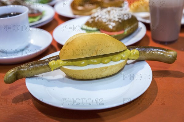 DEU Germany Germany Berlin Scene of the Green Weeks, the annual trade fair for food, agriculture and ecology. Bratwurst with mustard in a roll as an example of fast food