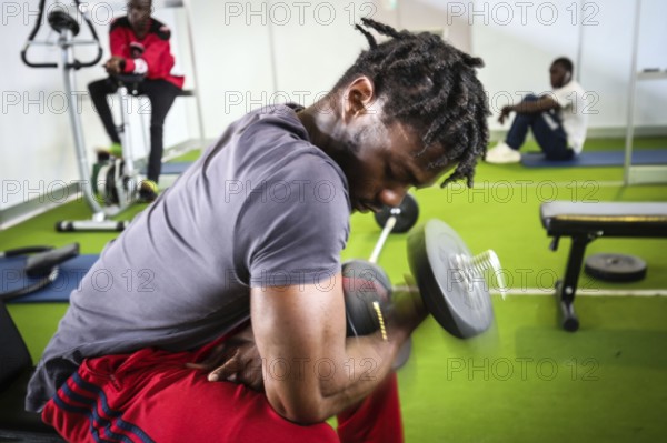 DEU Germany Germany Berlin As part of the German Foundation Week, the Cologne-based organisation Rheinflanke demonstrates sports facilities for refugees in the hangar at Tempelhof Airport. African refugees do exercises in a weight room in Hangar 1
