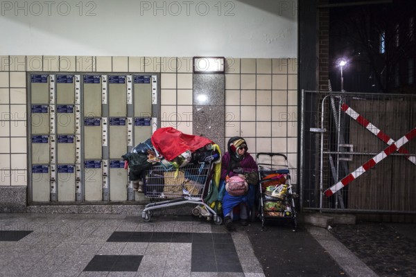 DEU Germany Germany Berlin Scenes of homeless people around Bahnhof Zoo. Woman with her belongings sitting next to lockers