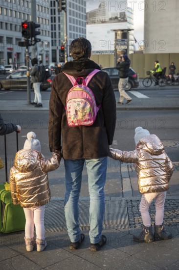 DEU Germany Germany Berlin A father holds hands with his twin daughters at a pedestrian crossing on Potsdamer Platz