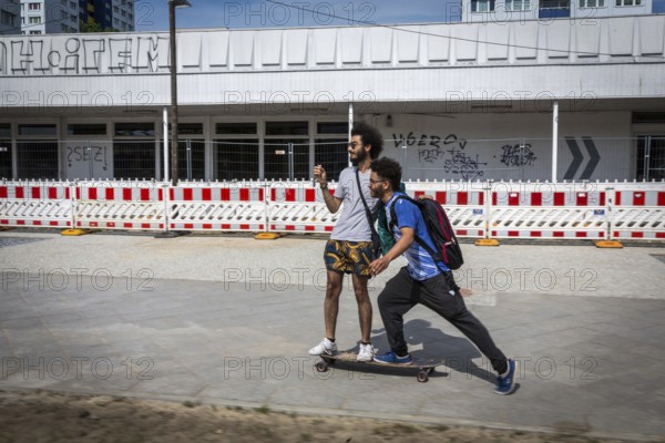 DEU Germany Germany Berlin Two friends move through Berlin on a skateboard