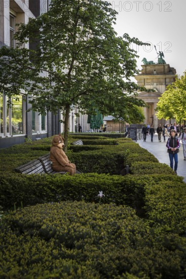 DEU Germany Germany Berlin A man in a bear costume waits on a bench for the attention of passing tourists near the Brandenburg Tor