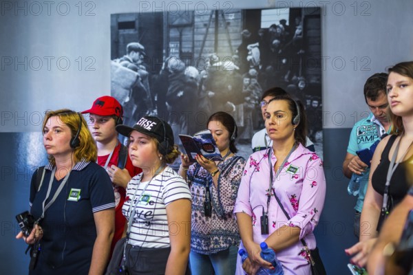 POL Poland Poland Auschwitz Visitors listen to their audio guide at the memorial site of the former Auschwitz concentration camp