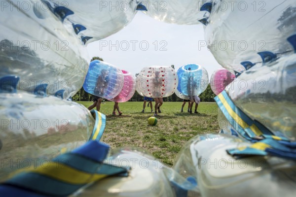 DEU Germany Germany Berlin A group of Dutch tourists playing bubblesoccer in a meadow in Volkspark Friedrichshain