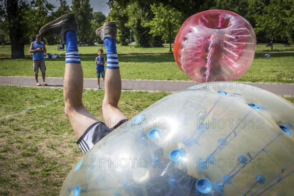 DEU Germany Germany Berlin A group of Dutch tourists playing bubblesoccer in a meadow in Volkspark Friedrichshain