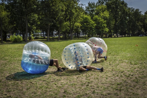 DEU Germany Germany Berlin A group of Dutch tourists playing bubblesoccer in a meadow in Volkspark Friedrichshain
