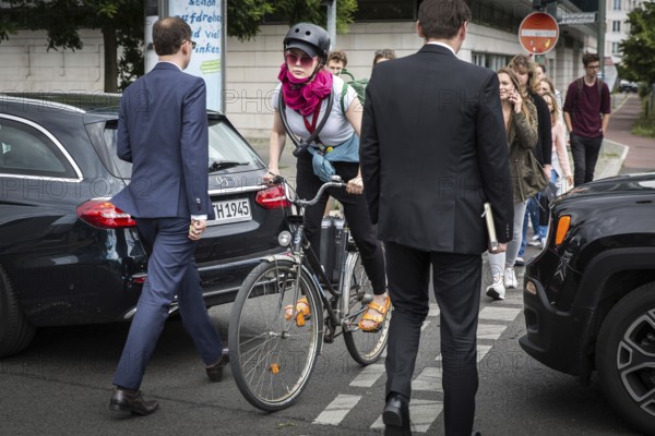 DEU Germany Germany Berlin Cyclist and pedestrian queue through heavy traffic on Klingenhoeferstrasse