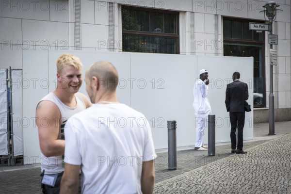 DEU Germany Germany Berlin Supporters of the Senegalese president in front of the Ritz Carlton Hotel at Potsdamer Platz. Two construction workers stand at a distance from two Senegalese