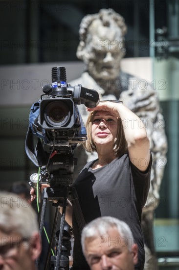 DEU Germany Germany Berlin The SPD chairman and candidate for chancellor Martin Schulz during a press conference on economic policy in the Willy Brandt House. TV camerawoman protects herself from the blinding sun. The Willy Brandt statue in the background