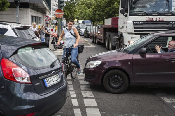 DEU Germany Germany Berlin Cyclist battles her way through heavy traffic on Klingenhoeferstrasse