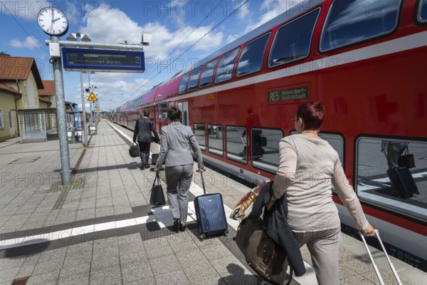 DEU Germany Germany Neubrandenburg Passengers with wheeled suitcases in front of boarding a regional train