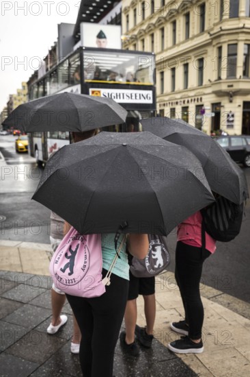 DEU Germany Germany Berlin Tourists with umbrellas at Checkpoint Charlie