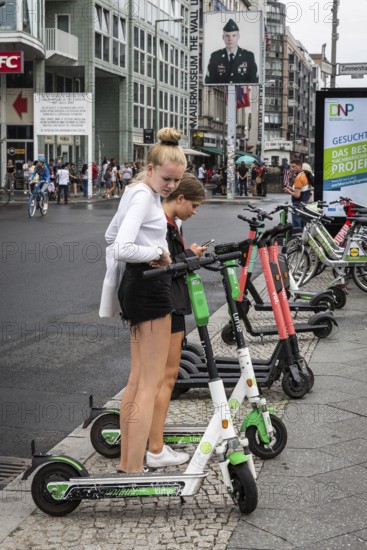 DEU Germany Germany Berlin Tourists with e-scooters at Checkpoint Charlie