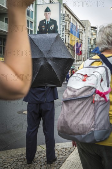 DEU Germany Germany Berlin Tourists with umbrellas at Checkpoint Charlie