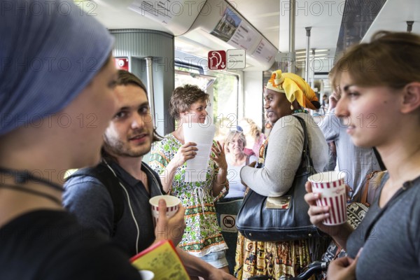 DEU Germany Germany Berlin Students discuss the G20 summit on the Berlin S-Bahn. A loose group of activists meet irregularly to discuss political issues with passengers over tea and food on the Ringbahn railway line