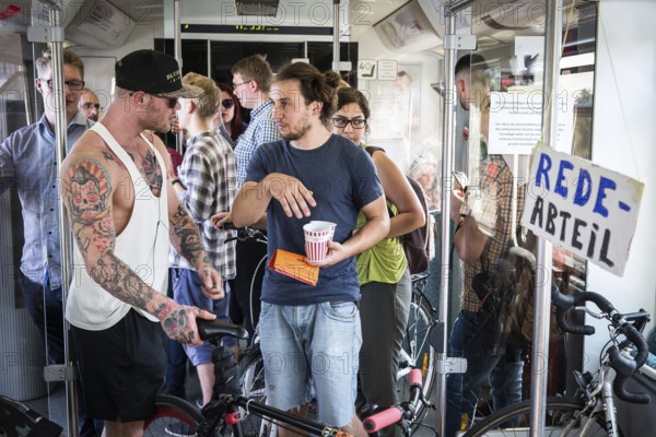 DEU Germany Germany Berlin Students discuss the G20 summit on the Berlin S-Bahn. A loose group of activists meet irregularly to discuss political issues with passengers over tea and food on the Ringbahn railway line
